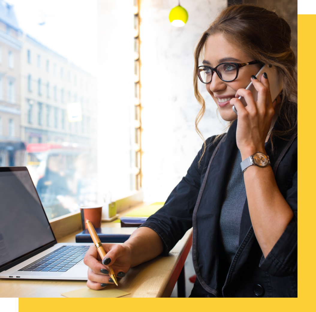 a woman sitting at a table talking on a cell phone.